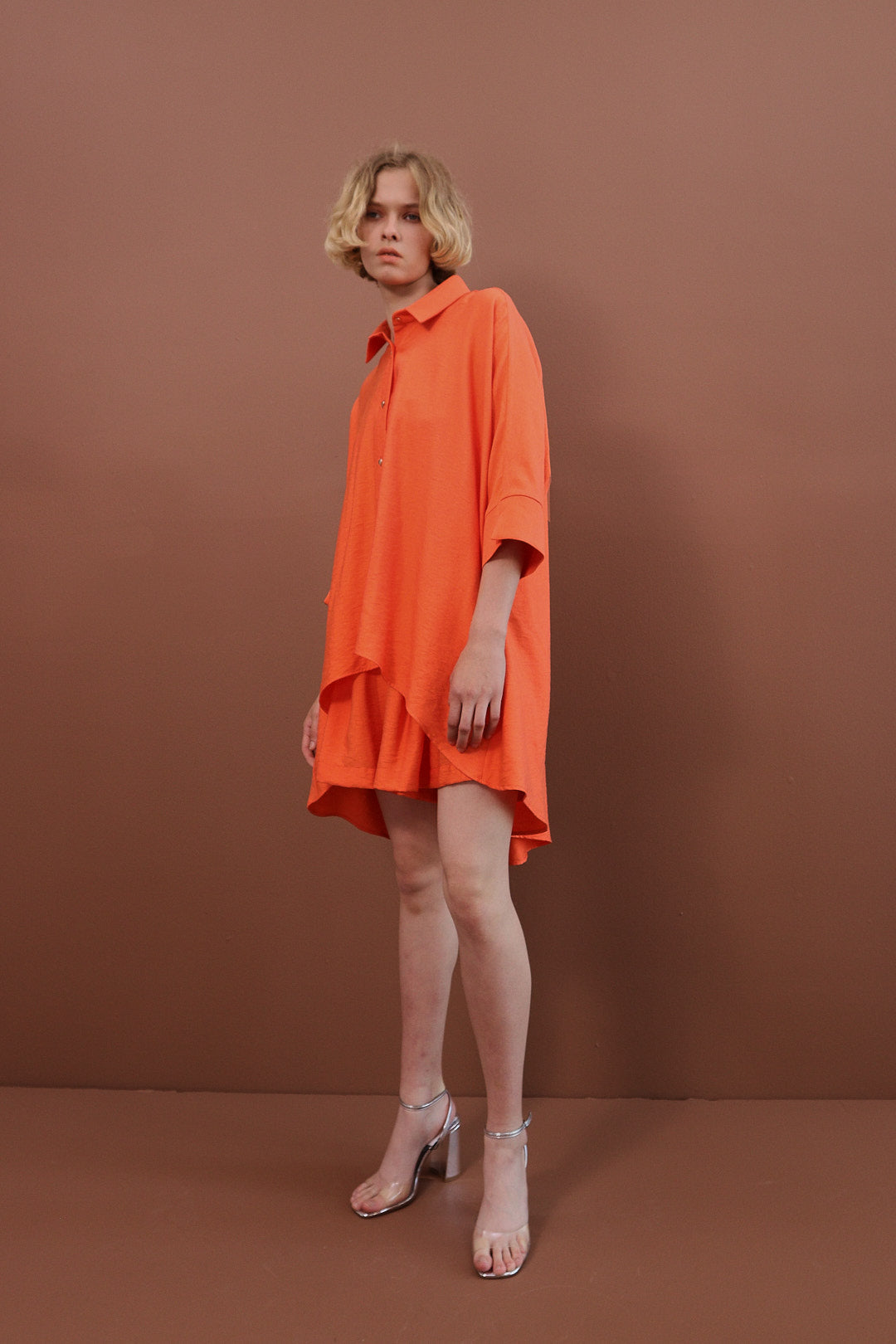 Traje naranja con shorts con botones en forma de corazón.