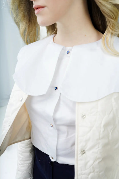Blusa Off-White con cuello Peter Pan y botones de corazón exclusivos