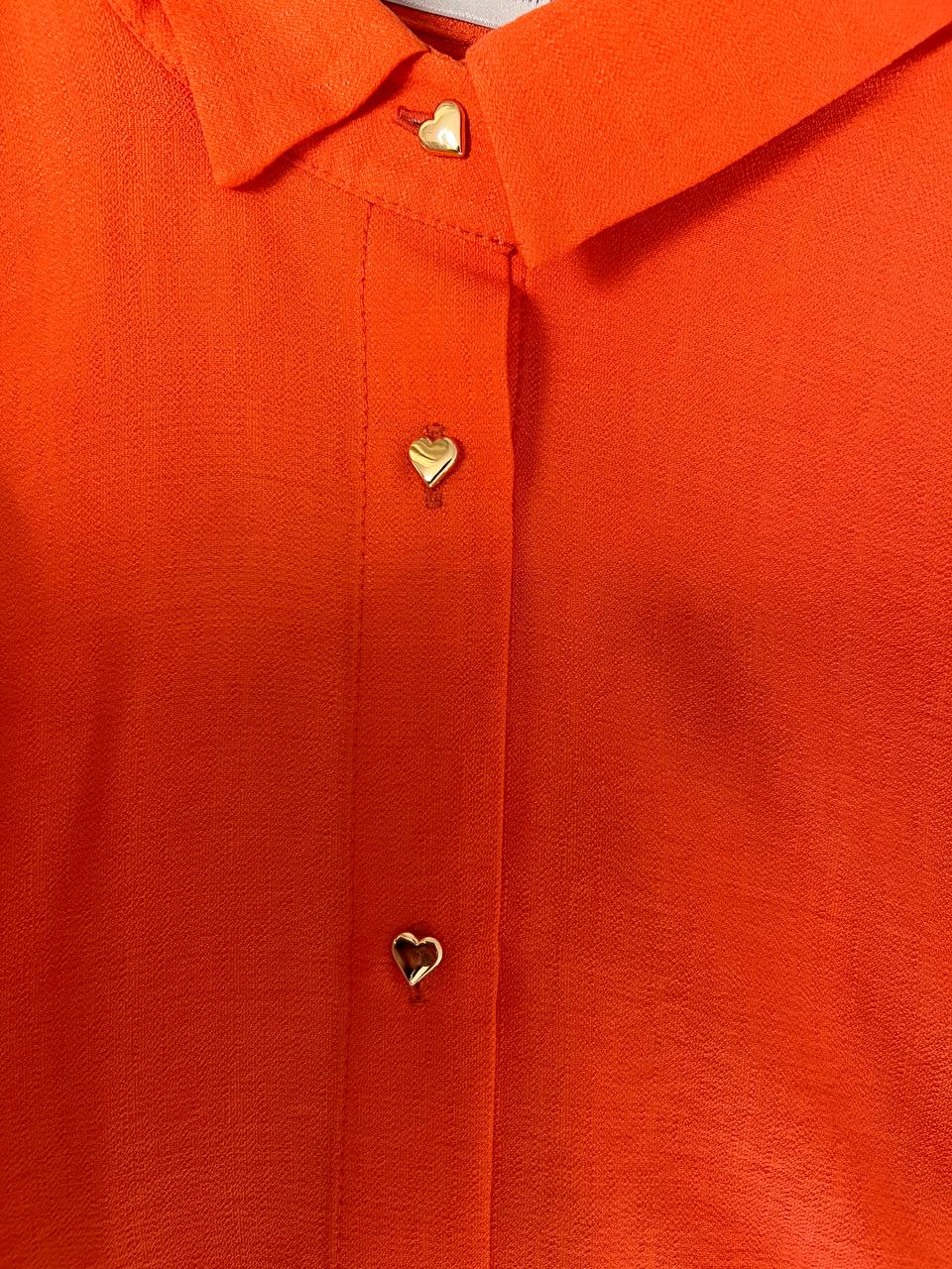 Помаранчовий костюм із пуговицями у вигляді серця.